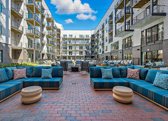 A courtyard with a blue couch and a brick floor.