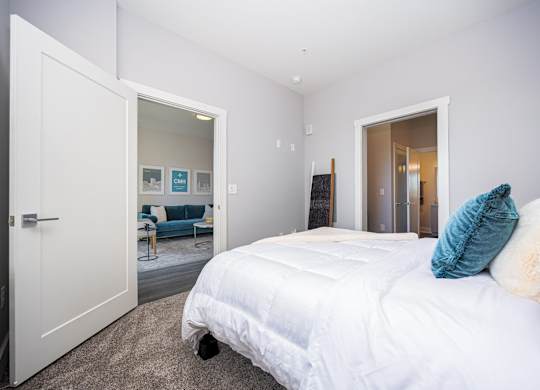 a bedroom with a white bed and a closet