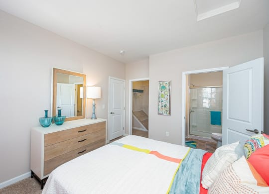 a bedroom with a bed and a mirror and a bathroom