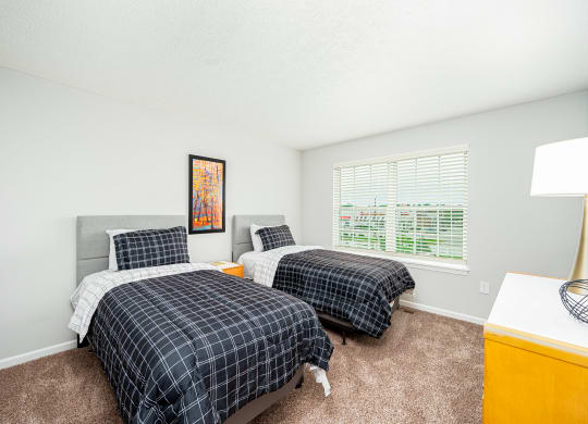 two beds in a room with two windows