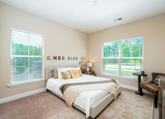 a bedroom with a bed and two windows