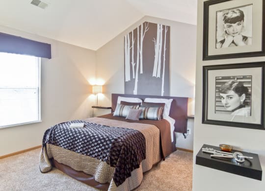 a bedroom with a bed and pictures on the wall