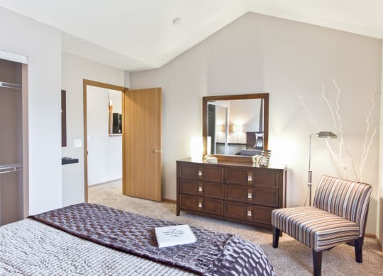 a bedroom with a bed and a chair and a dresser
