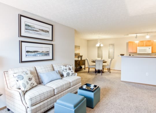 a living room with a couch and a table with a kitchen in the background
