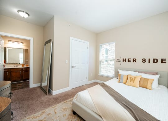 a bedroom with a large bed and a mirror