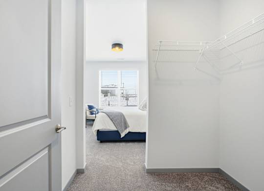 A bedroom with a bed, a chair, and a window.