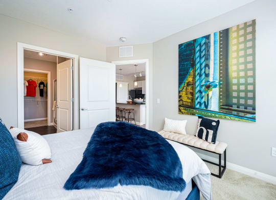 a bedroom with a large bed and a painting on the wall