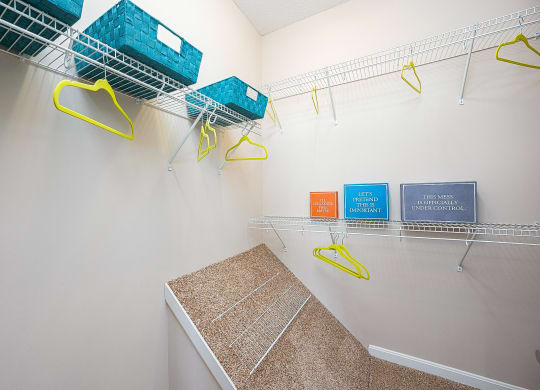 an empty closet with baskets and hooks on the wall