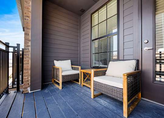 Two chairs and a table on a porch.