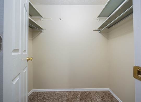 A white door with a gold handle is in a room with a brown carpet.
