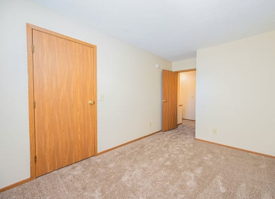 a bedroom with a closet and a door to a hallway