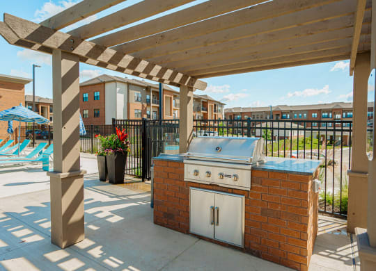 a patio with a barbecue grill and a pool