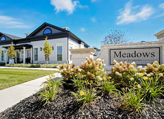 A sign that says Meadows in front of a house.