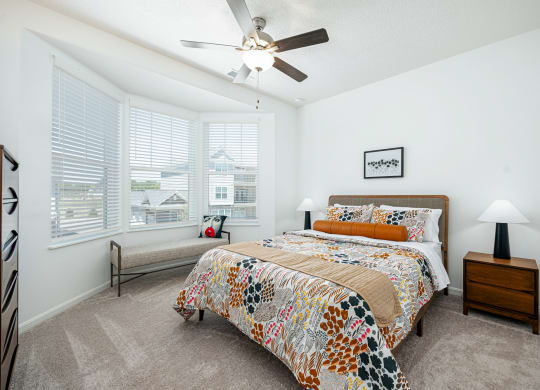 a bedroom with a bed and a ceiling fan