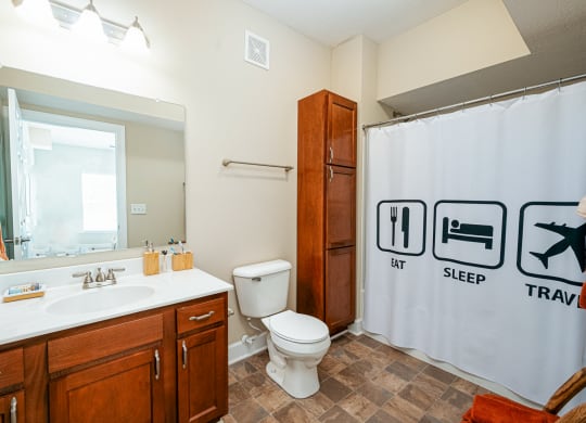 a bathroom with a shower curtain and a sink and a toilet