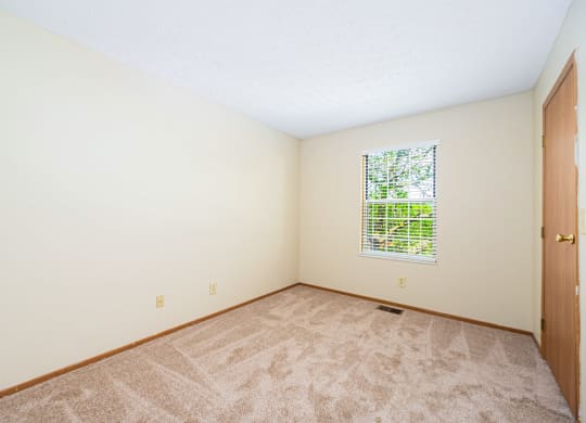 a room with carpet and a door and a window