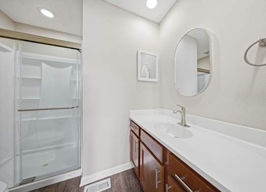 A bathroom with a white sink and a white fridge.