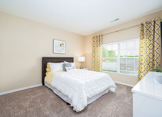 a bedroom with a bed and a large window