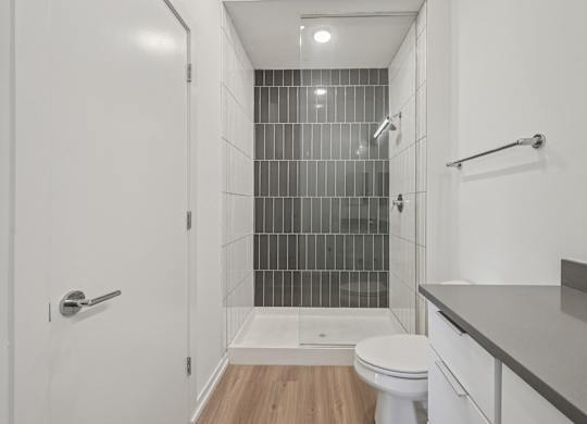 A white bathroom with a walk in shower and a toilet.