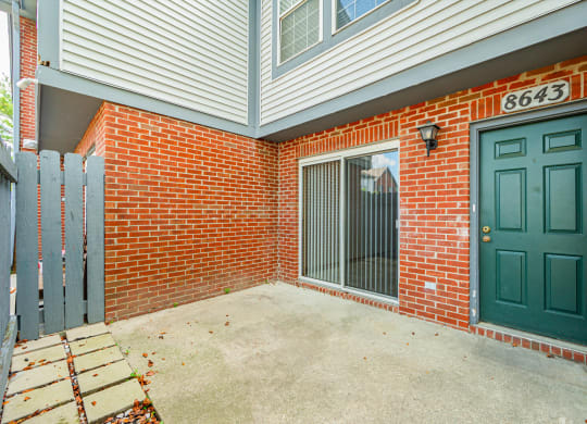 the entrance to a brick building with a green door