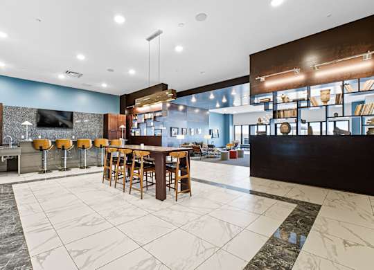 A modern bar area with a long wooden bar and stools.