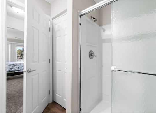 A white bathroom with a glass shower door.