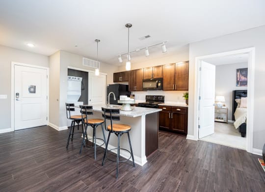a kitchen with a bar and stools in a living room