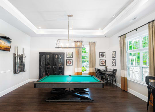 a living room with a pool table and a chandelier