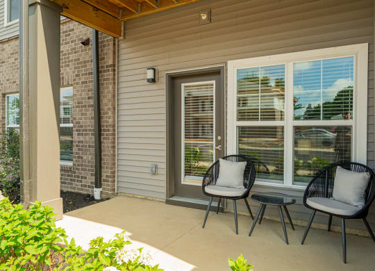 a patio with two chairs and a table on a porch