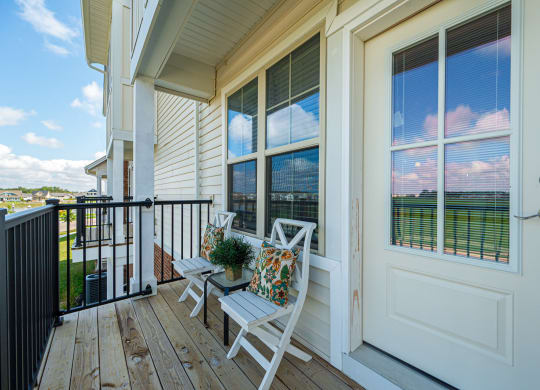 a balcony with chairs and a view of a building with windows