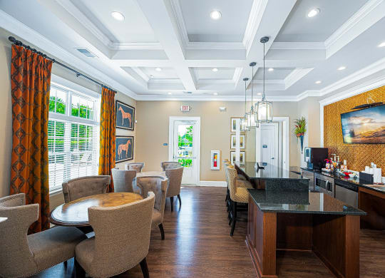 a living room with tables and chairs and a bar