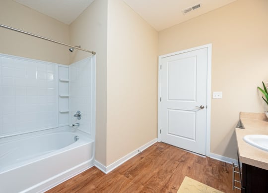 a bathroom with a tub and a shower and a sink