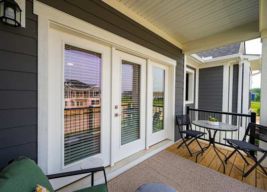 A patio with a table and chairs and a view of a house.