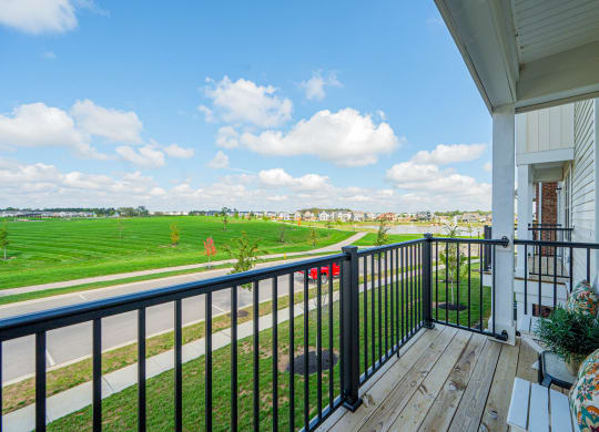 the view from the balcony of a house overlooking a field and a city