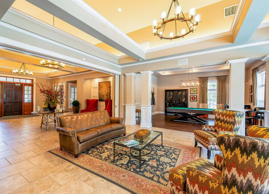 a living room with couches and a pool table
