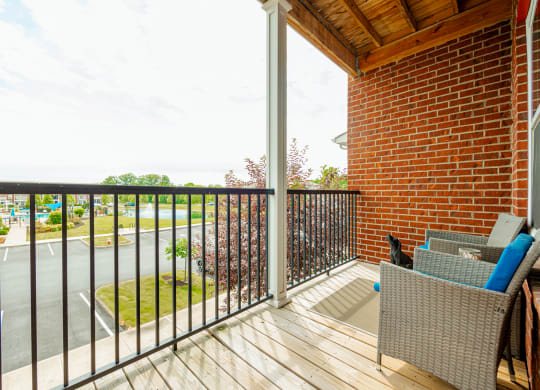 a balcony with a brick wall and a wooden deck