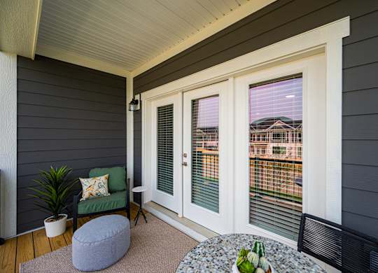 A small balcony with a table and chairs.