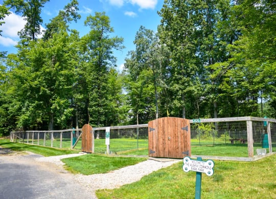 a gate in a fenced in area with trees in the background
