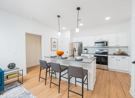 an open kitchen with a large island with three stools
