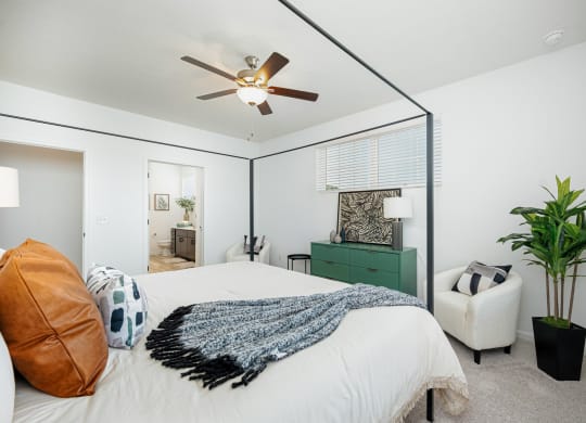 a bedroom with a large bed and a ceiling fan