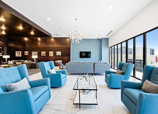 A living room with blue chairs and a black coffee table.