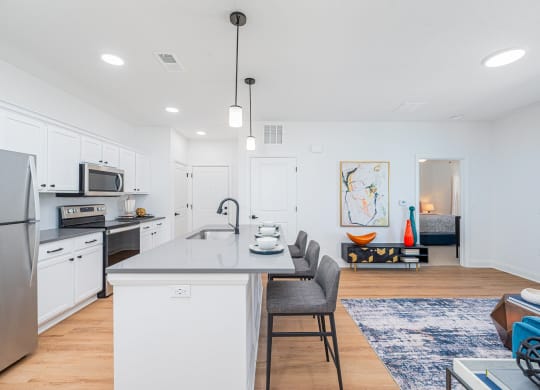 an open kitchen and living room with an island and a dining room table