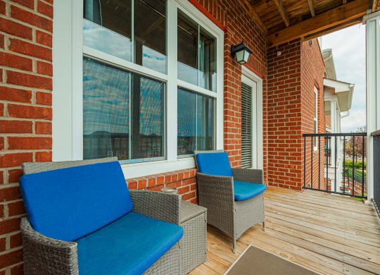 a patio with chairs and a brick wall
