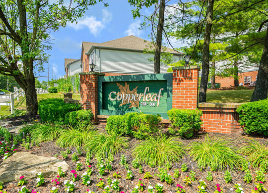 the sign for copperleaf apartments with trees and flowers