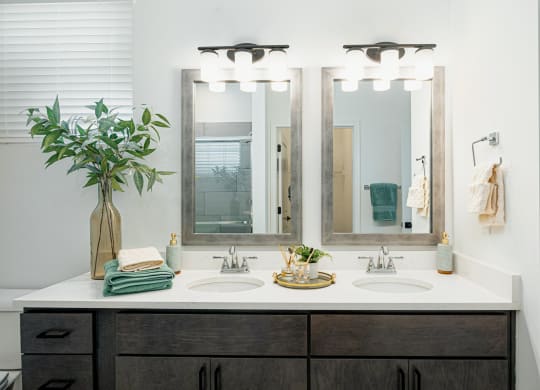a bathroom with two sinks and three mirrors