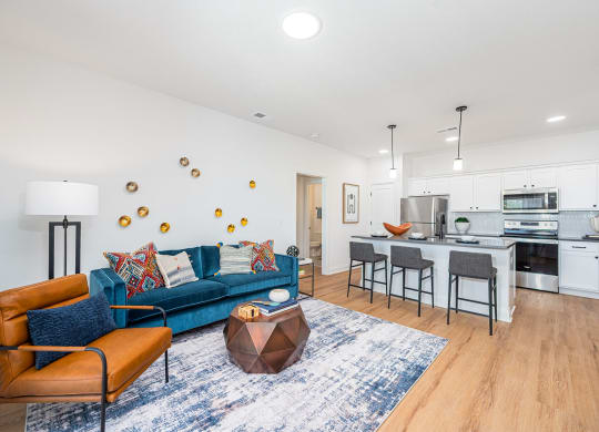 a living room with a blue couch and a kitchen with a counter