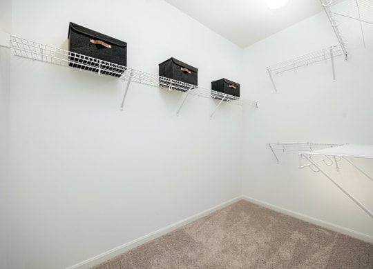 a spacious closet with shelves and hanging racks on the wall