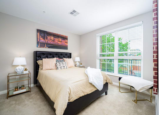 a bedroom with a bed and a large window