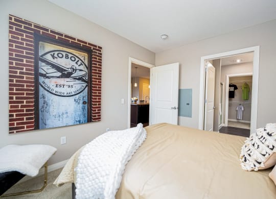 a bedroom with a bed and a painting on the wall