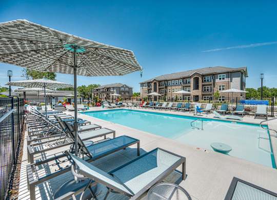 A sunny day at the pool with lounge chairs and umbrellas.